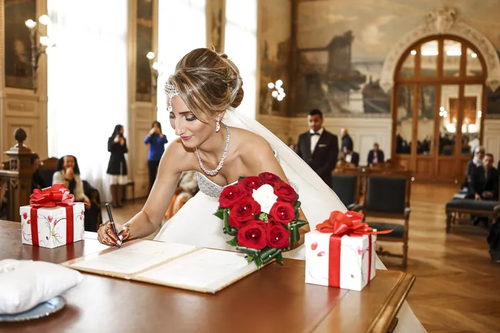 Mariée qui signe le registre dans une salle des mariages